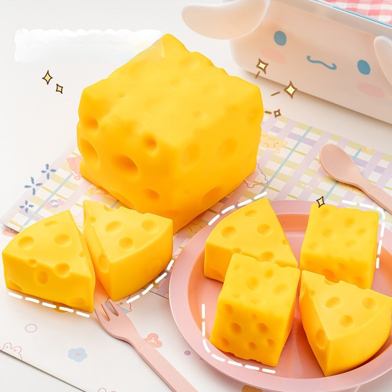 Cheese squishy, Yellow cheese-like blocks on a pink plate with a cartoon cow in the background