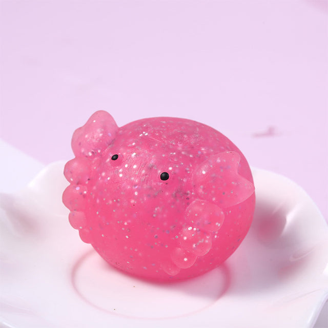 Mochi squishy Pink glittery duck-shaped object on a white plate with a pink background