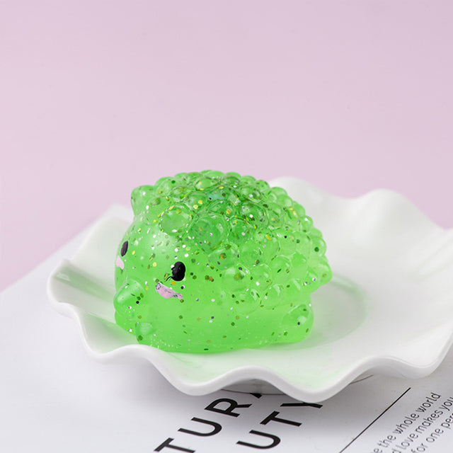 Green Mochi squishy, Green textured squishy toy on a white dish with a pink background
