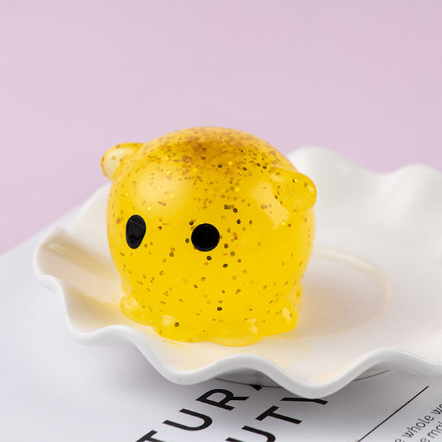Yellow color Mochi squishy, Yellow textured object with black eyes on a white plate against a light purple background