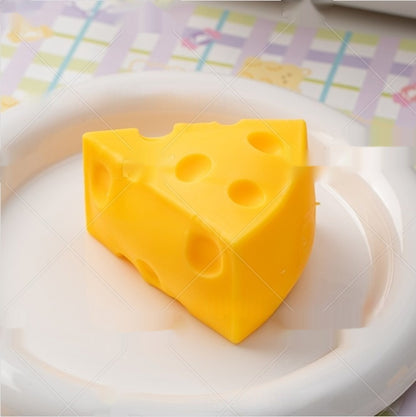 cheese squishy, Yellow cheese-shaped object on a white plate with a colorful checkered tablecloth in the background
