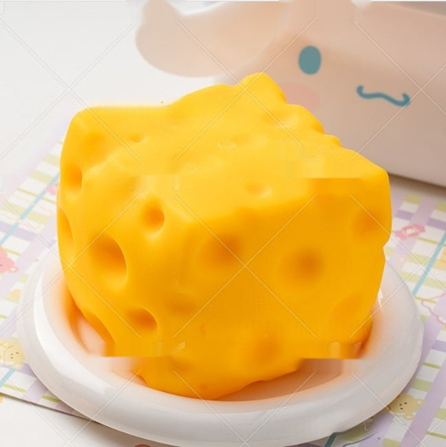 cheese squishy, Yellow cheese-shaped object on a white plate with a colorful background