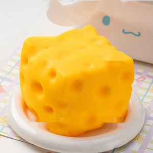cheese squishy, Yellow cheese-shaped object on a white plate with a colorful background
